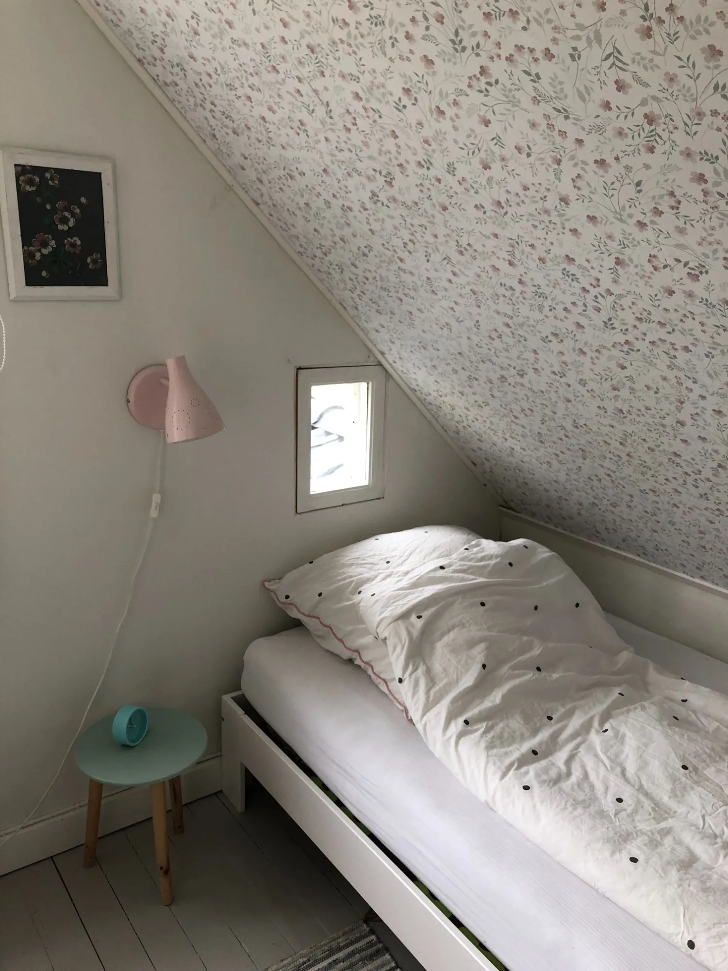 Bett unter einer Dachschräge mit Blumentapete