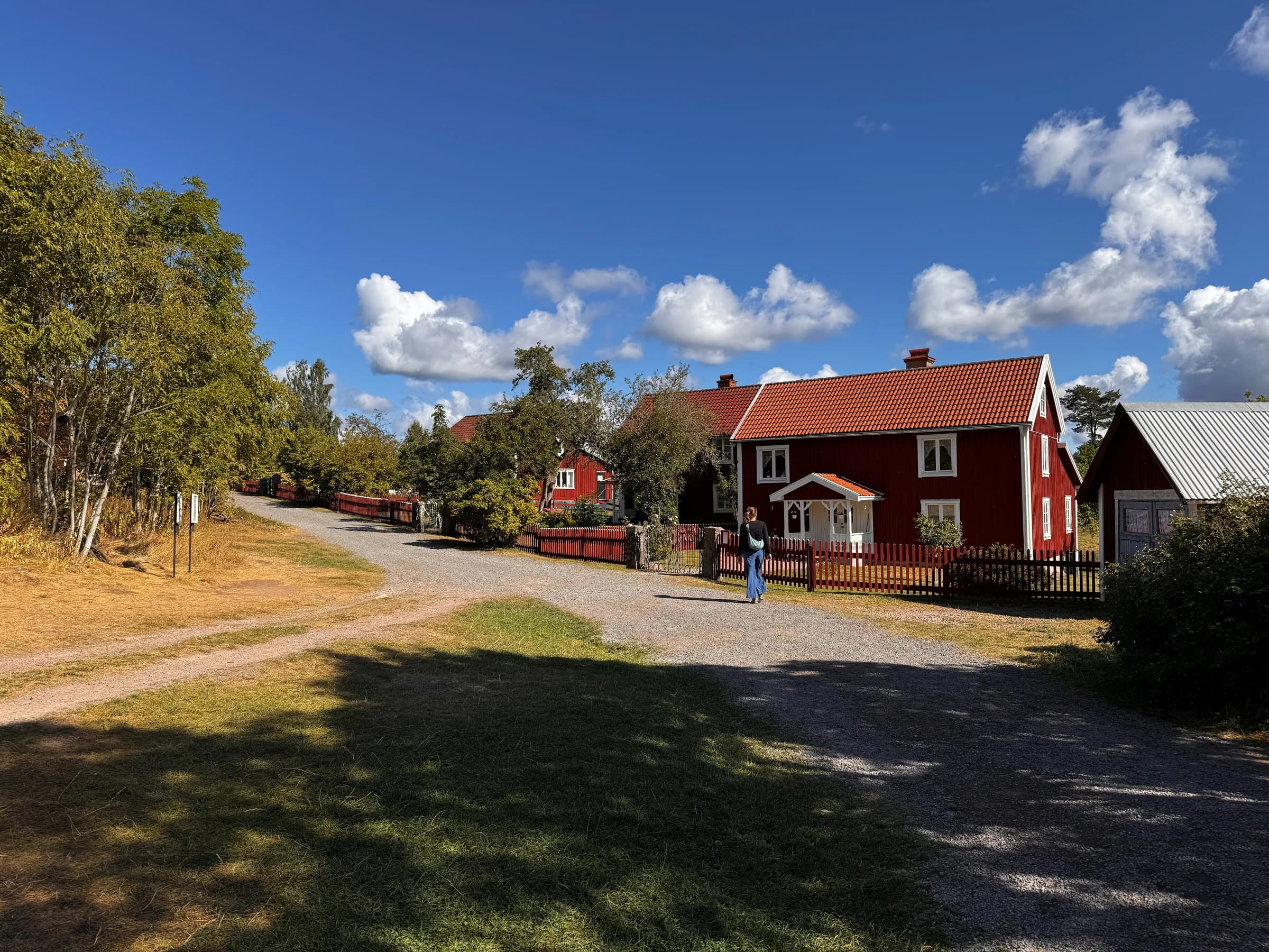 Röda trähus vid en grusväg i Sevedstorp