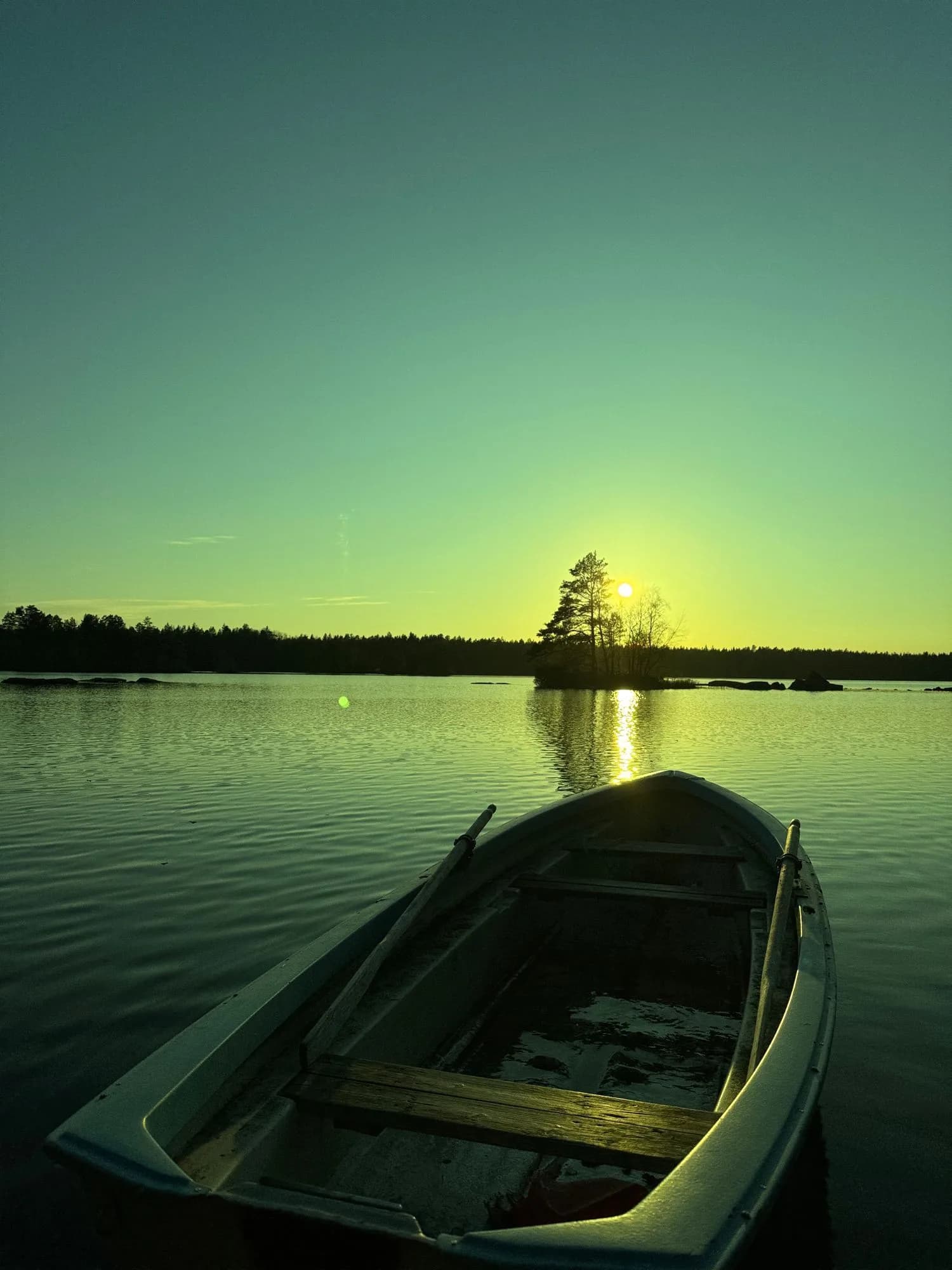Ruderboot auf einem ruhigen See im Abendlicht