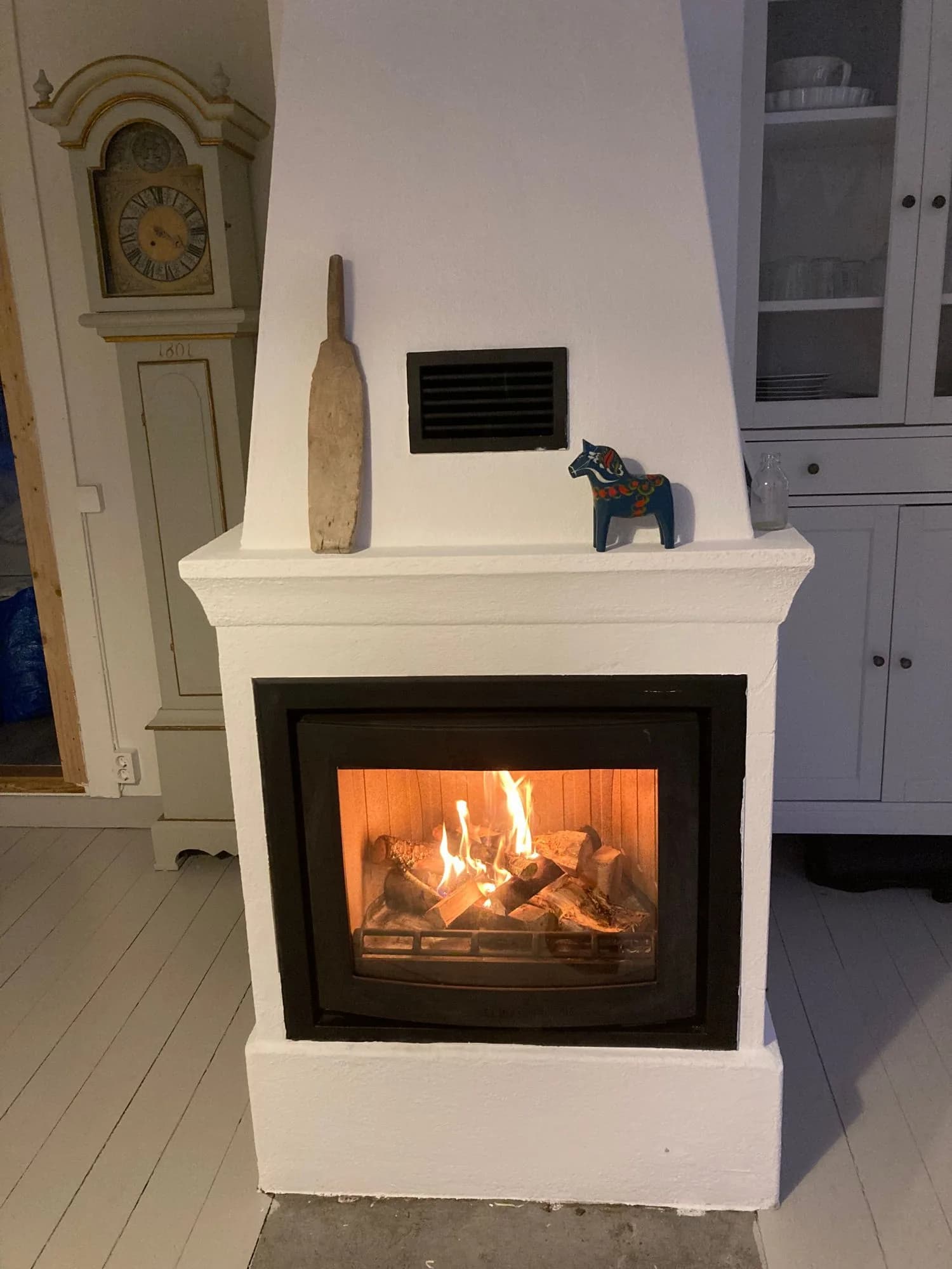 Kamin mit Dalahäst und traditioneller Wanduhr